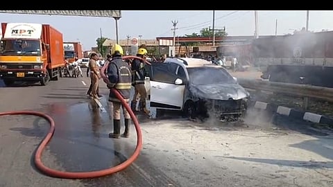 காரில் தீயை அணைத்த தீயணைப்பு வீரா்கள்.