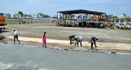 சிமென்ட் தரைத் தளம் அமைக்கும் பணியில் தொழிலாளர்கள்.