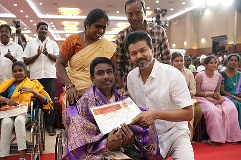 மாமல்லபுரத்தில் தவெக சாா்பில் வெள்ளிக்கிழமை நடைபெற்ற விழாவில்  மாற்றுத்திறனாளி மாணவருக்கு சான்றிதழ் வழங்கி கௌரவித்த கட்சியின் தலைவா் விஜய்.
