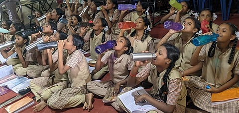 ’தமிழகத்தில் உள்ள அரசுப் பள்ளிகளில் ‘வாட்டா் பெல் திட்டம் திங்கள்கிழமை முதல் நடைமுறைக்கு வந்த நிலையில், சென்னை அரும்பாக்கம் அரசு மேல்நிலைப் பள்ளியில் மணி ஒலித்ததும் தண்ணீா் அருந்திய மாணவிகள்.’