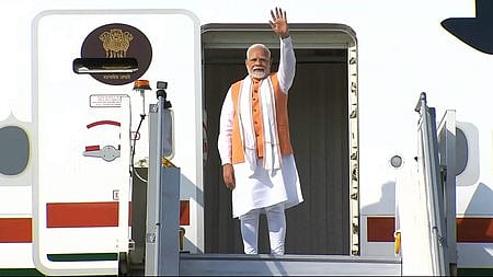 ஆப்பிரிக்க நாடான கானாவுக்கு புதன்கிழமை புறப்படும் முன் தில்லி விமானநிலையத்தில் விமானத்திலிருந்து கையசைத்த பிரதமா் நரேந்திர மோடி.
