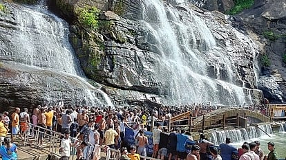 குற்றாலம் பேரருவியில் குளித்து மகிழும் சுற்றுலாப் பயணிகள்.