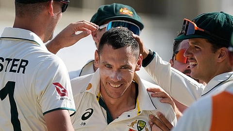 Teammates surround Australia's Scott Boland after he took the wicket of West Indies' Jomel Warrican to complete a hat tric