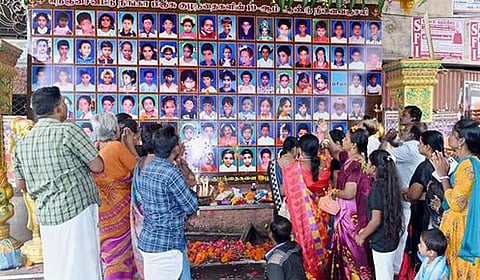 கும்பகோணம் காசிராமன் தெருவிலுள்ள பள்ளி முன் வைக்கப்பட்டுள்ள குழந்தைகளின் பதாகைக்கு புதன்கிழமை மலா்தூவி அஞ்சலி செலுத்தும்  மக்கள்.