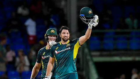 Tim David raises his helmet in joy after scoring a century.