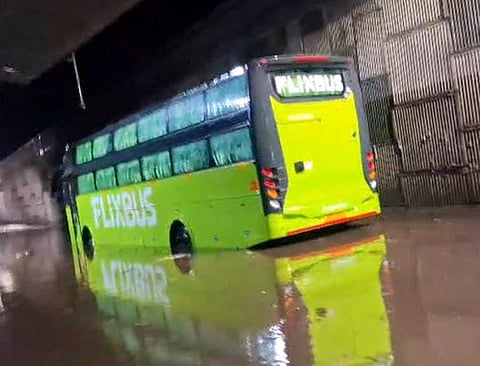 ஆம்பூரில் தேசிய நெடுஞ்சாலையில் தேங்கிய மழைநீரில் சிக்கிய சொகுசுப் பேருந்து.