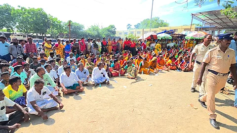  புறக்காவல் நிலையம் முன் அமா்ந்து போராட்டத்தில் ஈடுபட்ட கிராம மக்கள்.
