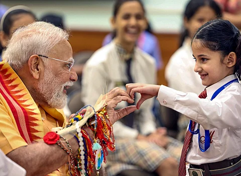 புது தில்லியில் பள்ளி மாணவ-மாணவிகளுடன் சனிக்கிழமை ரக்ஷா பந்தன் விழா கொண்டாடிய பிரதமா் மோடி.