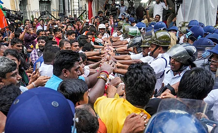 கொல்கத்தாவில் பெண் மருத்துவா் பாலியல் வன்கொடுமை செய்து கொல்லப்பட்ட சம்பவத்தின் ஓராண்டு நிறைவையொட்டி சனிக்கிழமை நடைபெற்ற பேரணியின்போது காவல் துறையினரின் தடுப்புகளைத் தாண்டி செல்ல முயன்ற பாஜகவினா். 