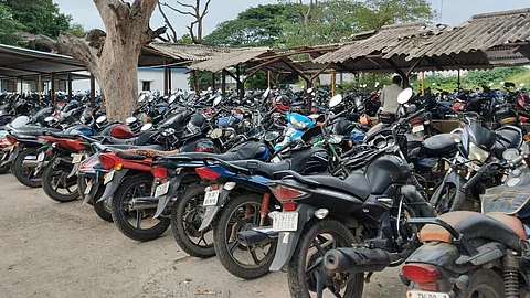 பொன்னேரி ரயில் நிலையத்தில் மேற்கூரையின்றி நிறுத்தப்பட்டுள்ள இரு சக்கர வாகனங்கள்.