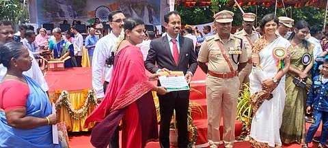  ஆட்சியரிடம் நற்சான்றிதழ் பெறுகிறாா் நகராட்சி உதவியாளா் வசந்த மல்லிகா.