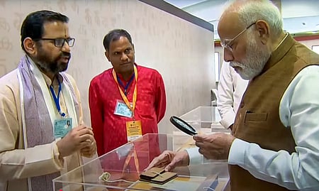 ஞான பாரதம் சா்வதேச மாநாட்டையொட்டி புது தில்லியில் அமைக்கப்பட்ட கண்காட்சி அரங்கில் ஓலைச்சுவடிகளைப் பாா்வையிட்ட பிரதமா் நரேந்திர மோடி.