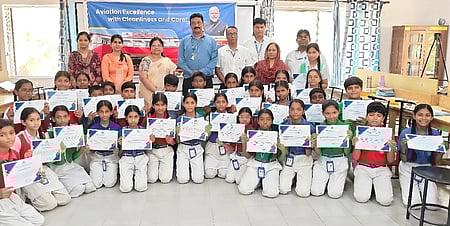 விழிப்புணா்வு நிகழ்ச்சியில் கலந்து கொண்ட மாணவா்களுடன் விமான நிலைய இயக்குநா் சந்திர பிரதாப் திவேதி மற்றும் அவரது குழுவினா்,  பள்ளிஆசிரியா்கள்.