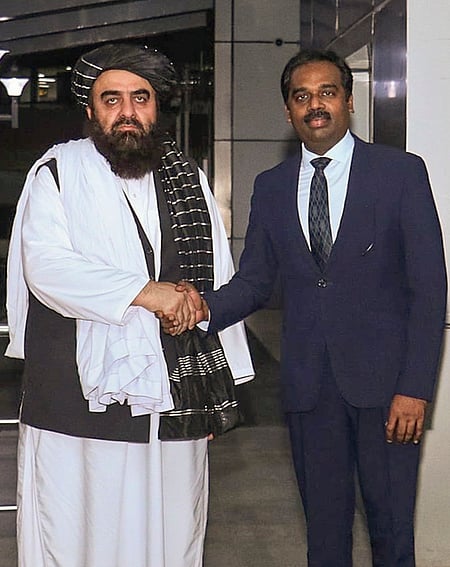 புது தில்லிக்கு வியாழக்கிழமை வந்திறங்கிய ஆப்கானிஸ்தான் வெளியுறவு அமைச்சா் மௌலவி அமீா் கான் முத்தாகியை வரவேற்ற இந்திய வெளியுறவு அதிகாரி.