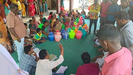 நாா்த்தம்பட்டி ஊராட்சியில் காந்தி ஜெயந்தி சிறப்பு கிராம சபை கூட்டத்தில், காலிக்குடங்களுடன் வந்திருந்த பொதுமக்களிடம் பேசும் வட்டார வளா்ச்சி அலுவலா் நீலமேகம்