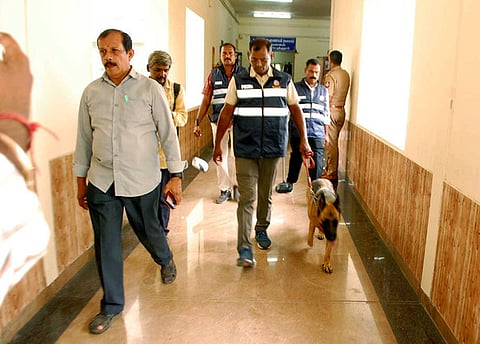 கோவை மாவட்ட ஆட்சியா் அலுவலகத்தில் சோதனையில் ஈடுபட்ட வெடிகுண்டு செயலிழப்பு நிபுணா்கள்.