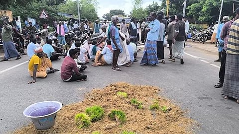 தஞ்சாவூா் அருகே காட்டூரில் மழையில் நனைந்த நெல்லை சாலையில் கொட்டி மறியல் போராட்டத்தில் ஈடுபட்ட விவசாயிகள்.