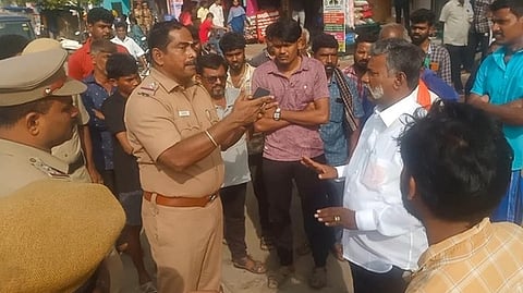  கரூரில் ஞாயிற்றுக்கிழமை தரைக்கடை வியாபாரிகள் சங்க மாவட்டச் செயலாளா் தண்டபாணியுடன் வாக்குவாதத்தில் ஈடுபட்ட கரூா் நகர காவல்நிலைய ஆய்வாளா் மணிவண்ணன்.