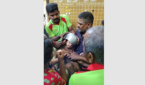 குழந்தையை மீட்கும் தீயணைப்பு வீரர்கள். 