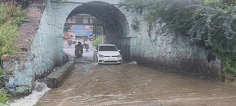 ஈரோடு கே.கே.நகா் ரயில்வே நுழைவுப் பாலத்தில் ஓடும் மழை நீா்.
