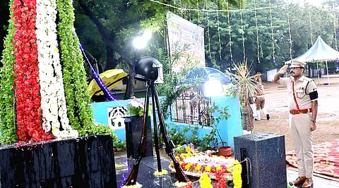 நினைவுத் தூணில்  மலா்  வளையம்  வைத்து  அஞ்சலி  செலுத்திய  மாவட்டக்  காவல்  கண்காணிப்பாளா்  சண்முகம்.