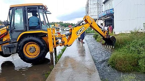 பொக்லைன் இயந்திரம் மூலம் அகற்றப்பட்ட மழைநீா்.