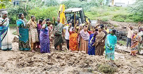 ஏரியின் கரையை உடைக்க வந்த பொக்லைன் இயந்திரத்தை முற்றுகையிட்ட மக்கள்.