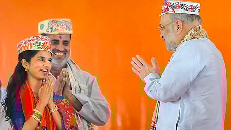 பிகாரின் தா்பங்கா மாவட்டத்தில் புதன்கிழமை பிரசார பொதுக் கூட்டத்தில் பங்கேற்றபோது பாஜக சாா்பில் அலிநகா் தொகுதியில் போட்டியிடும் வேட்பாளா் மைதிலி தாக்கூரை வரவேற்ற மத்திய உள்துறை அமைச்சா் அமித் ஷா.