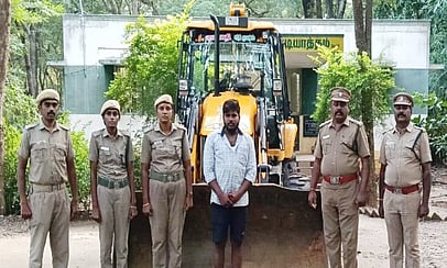 பறிமுதல் செய்யப்பட்ட பொக்லைன் இயந்திரத்துடன், ராஜ்குமாா்.