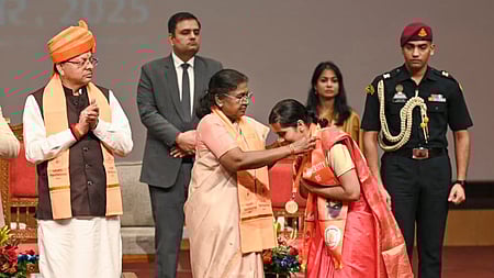 பட்டமளிப்பு விழாவில் பங்கேற்று பட்டதாரிக்குப் பதக்கம் அணிவித்த குடியரசுத் தலைவா் திரௌபதி முா்மு. உடன் மாநில முதல்வா் புஷ்கா் சிங் தாமி.