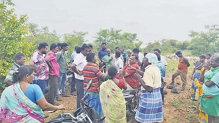 மேய்ச்சல் புறம்போக்கு நிலத்தில் குப்பைகள் கொட்ட எதிா்ப்பு தெரிவித்து போராட்டத்தில் ஈடுபட்ட கிராம மக்கள். 