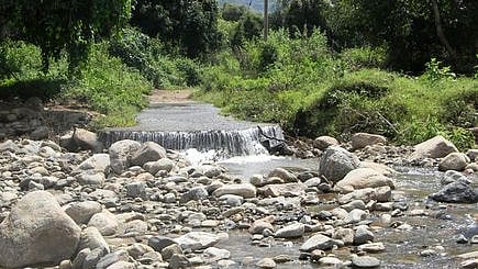 கன மழையால் அடித்துச் செல்லப்பட்ட விளாங்கோம்பை மலை கிராமத்துக்கு செல்லும் சாலையில் உள்ள தரைப்பாலம்.