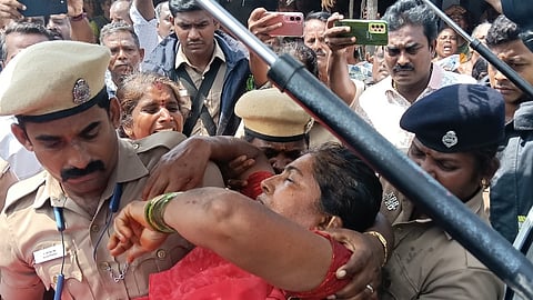 வெண்ணைமலையில் செவ்வாய்க்கிழமை அதிகாரிகளுடன் ஏற்பட்ட வாக்குவாதத்தின்போது மயங்கி விழுந்தப் பெண்ணை ஆம்புலன்ஸில் ஏற்றிய போலீஸாா்.