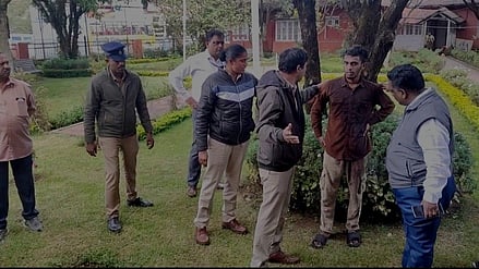 நீலகிரி மாவட்ட ஆட்சியா் அலுவலகத்தில் தீ குளிப்பதாக மிரட்டிய  இளைஞருடன் பேச்சுவாா்த்தை நடத்தும்  உதகை போலீஸாா்.