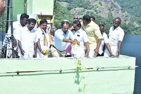 அடவிநயினாா் கோயில் நீா்த்தேக்கத்திலிருந்து தண்ணீரைத் திறந்துவைத்து மலா்களைத்  தூவினாா்  மாவட்ட ஆட்சியா் ஏ.கே.கமல்கிஷோா். உடன், எஸ்.பழனிநாடாா் எம்எல்ஏ. 