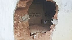 மதுபானக் கடையின் பின்பக்க சுவரில் மா்ம நபா்களால் இடப்பட்ட துளை. 