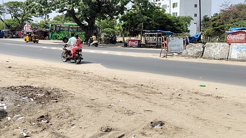 ராமேசுவரம் பேருந்து நிலையம் அருகே சாலையில் படிந்த மணல்.

