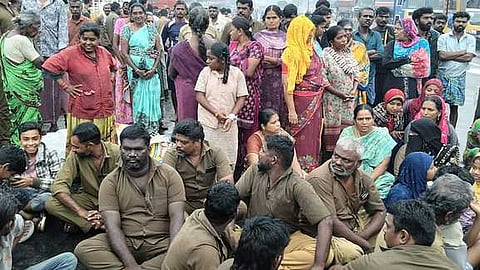 கோவை - திருச்சி தேசிய நெடுஞ்சாலையில் தங்களது குடும்பத்தினருடன் அமா்ந்து சாலை மறியலில் ஈடுபட்ட ஆட்டோ ஓட்டுநா்கள்.