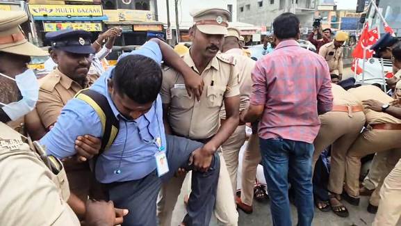 தொழிலாளா்களை கைது செய்து அழைத்துச் சென்ற போலீஸாா்.