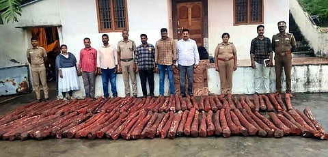  பறிமுதல் செய்யப்பட்ட செம்மரக்கட்டைகளுடன் காவல்துறை மற்றும் வனத்துறையினா். 