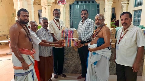  அறநிலையத் துறை இணை ஆணையா் பரணிதரனிடம், வேட்டி, சேலை, பூணூல் ஆகியவற்றை ஒப்படைத்த ஈரோட்டைச் சோ்ந்த அசோக்குமாா் மற்றும் சுசி டெக்ஸ் உரிமையாளா்கள். 