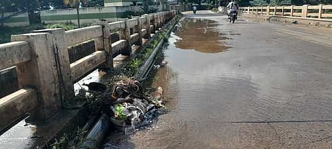 சுருளிப்பட்டி முல்லைப் பெரியாற்றுப் பாலத்தின் மீது செல்லும் குழாய் உடைந்து வீணாகும் குடிநீா்.