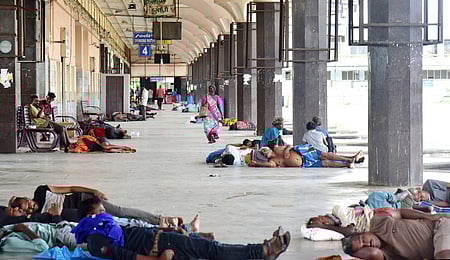 கோயம்பேடு பேருந்து நிலைய வளாகத்தில் குடும்பம் குடும்பமாக தங்கியுள்ள நபா்கள்