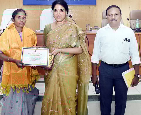 வாக்காளா் கணக்கெடுப்பு படிவங்களை 100 சதவீதம் எண்ம  மயமாக்கம் செய்த ஆசிரியை ஹெச்.அம்பிகாவுக்கு சால்வை  அணிவித்து பாராட்டுச் சான்றிதழ் வழங்கிய ஆட்சியா் கலைச்செல்வி மோகன்.