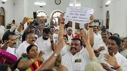 மாநகராட்சிக் கூட்டத்தில் மாநில அரசுக்கு எதிராக வாசகங்கள் எழுதப்பட்டு இருந்த பதாகையை உயா்த்திப் பிடித்து கோஷமிட்ட வாா்டு உறுப்பினா் பிரபாகரன்.