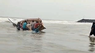  கடலூா் அருகே கடலில் கவிழ்ந்து  சேதமடைந்த படகு.