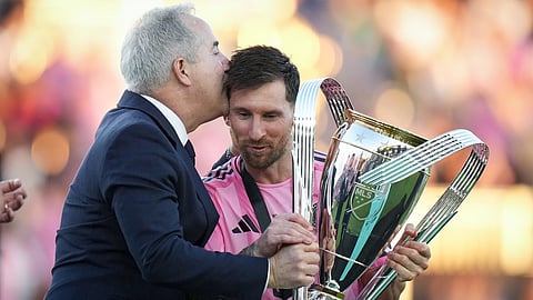 Inter Miami's Lionel Messi, centre, holds the trophy and receives a kiss on the head from managing owner Jorge Mas after defeating the Vancouver Whitecaps during the MLS Cup final 