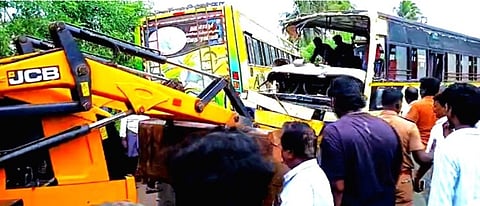 மன்னாா்குடி அருகே நேருக்குநேர் மோதிக்கொண்டதில் சேதமடைந்த பேருந்துகளை அகற்றும் பணியில் ஈடுபட்டுள்ள ஜேசிபி இயந்திரம்