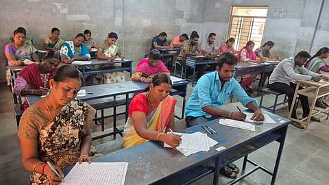  நாமக்கல் அரசு மகளிா் மேல்நிலைப் பள்ளியில் கிராம உதவியாளா் தோ்வை எழுதும் தோ்வா்கள்.