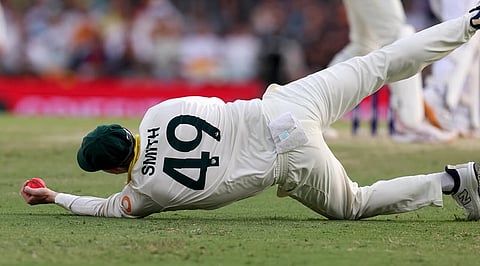 Steve Smith catches the ball with one hand.